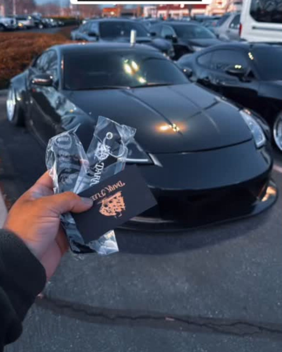 Personal holding Darkfleet merch infant of a Black Nissan 370z