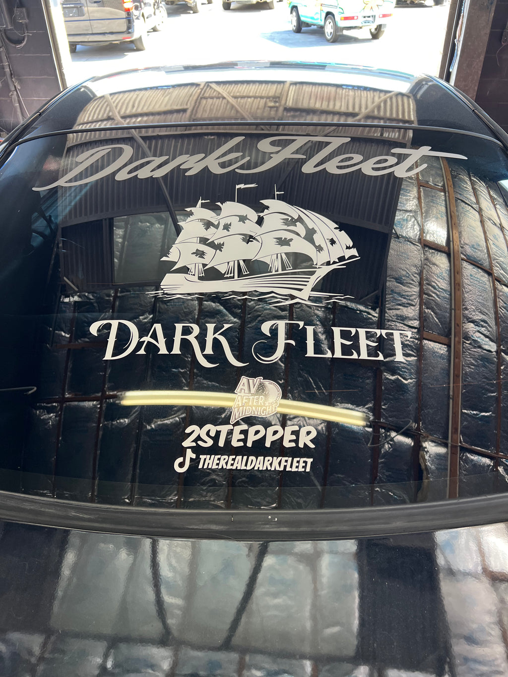 Dark Fleet logo on a car window with a ship illustration