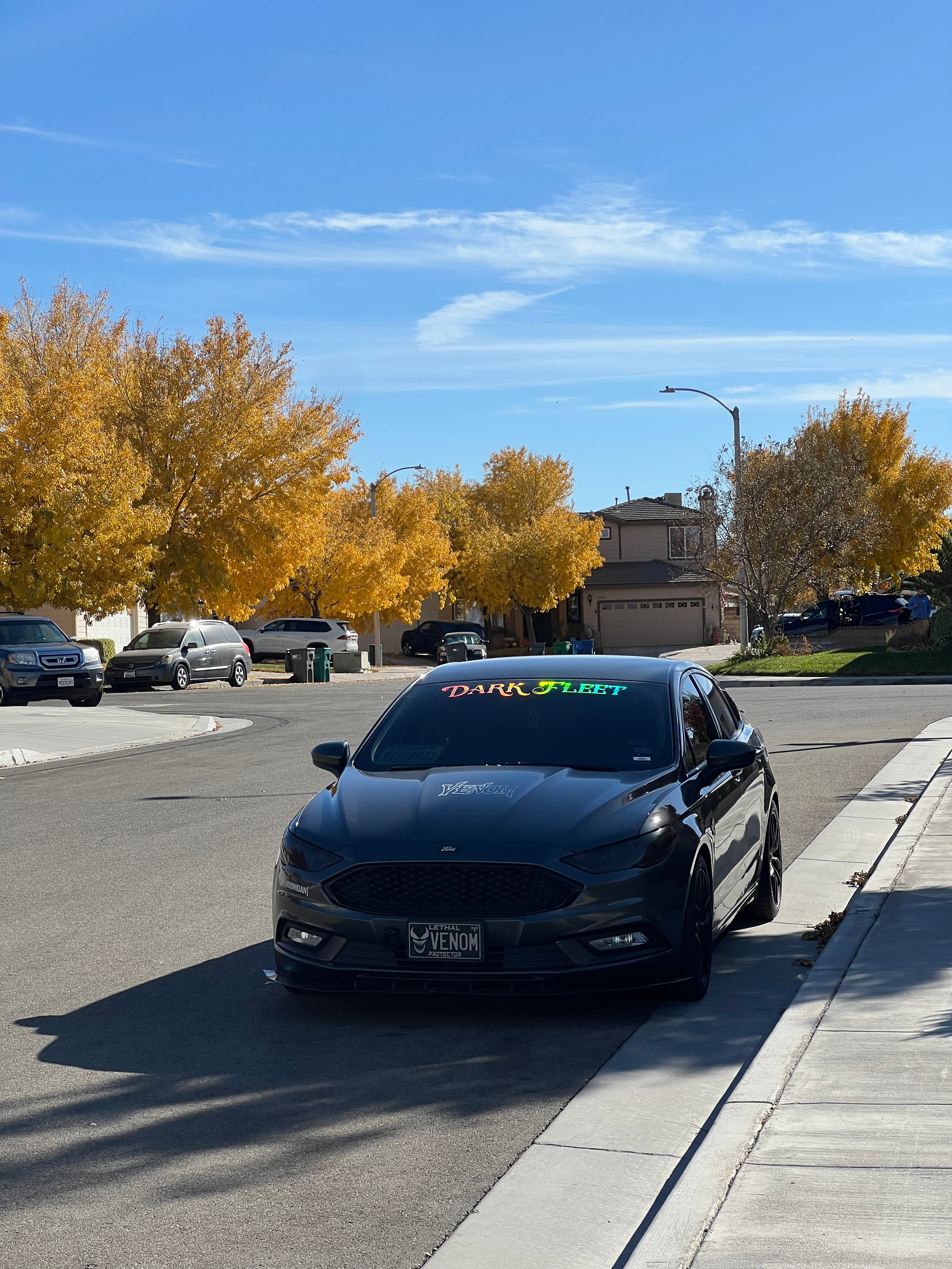 Dark Ford Fusion with a Darkfleet banner sticker on the windshield