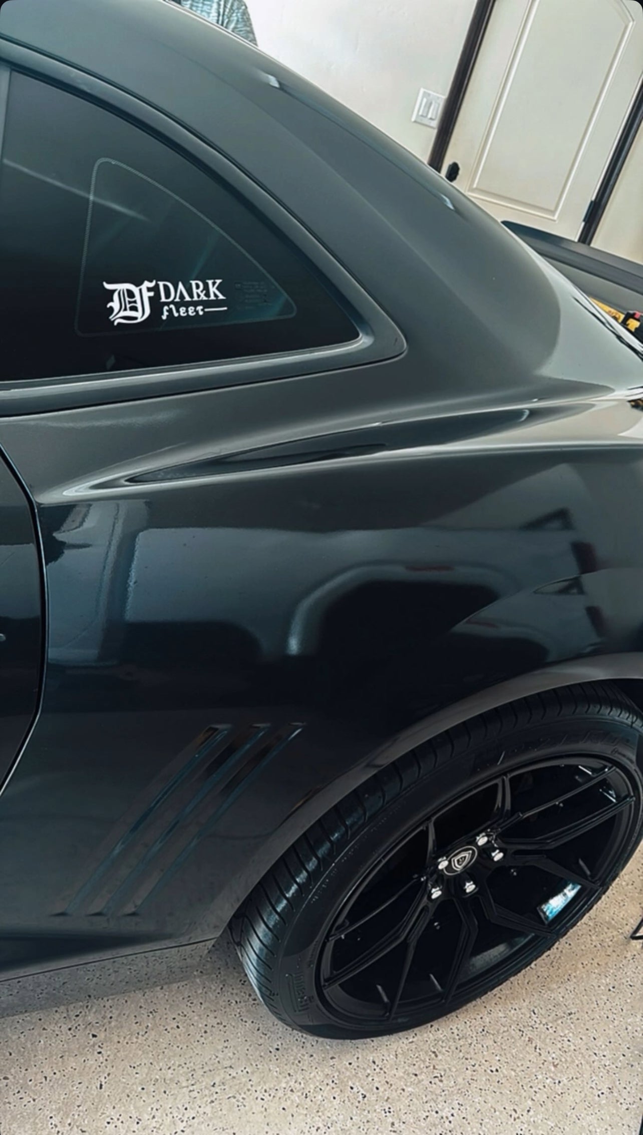 Black car with a visible brand logo in a garage